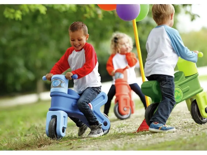 Motorcycle ride-on collection showing red, blue, and green models used for balance and mobility training.